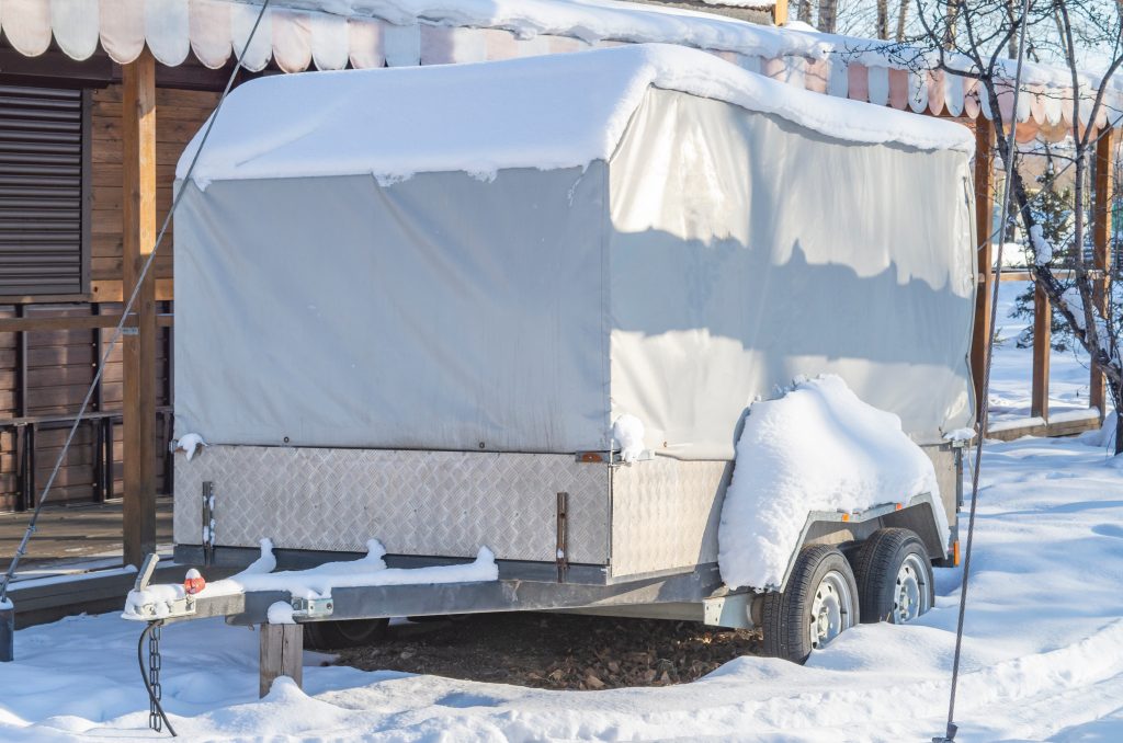 Motorhome RV, trailer, campervan parked near house under snow in winter - Wheelers RV Storage
